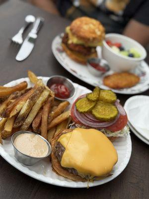 Breakfast sandwich with fried chicken and pimento cheese on a biscuit and the burger with fries.