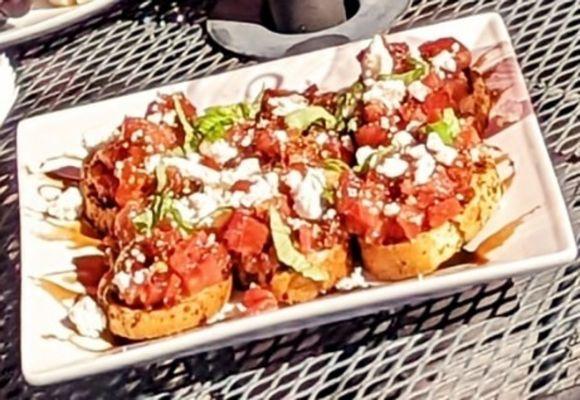 bruschetta with tomatoes, garlic and fresh basil topped with balsamic reduction and feta