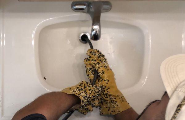 Snake cleaning a bathroom sink drain