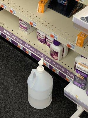 Half empty bottle of hand sanitizer stored on the floor