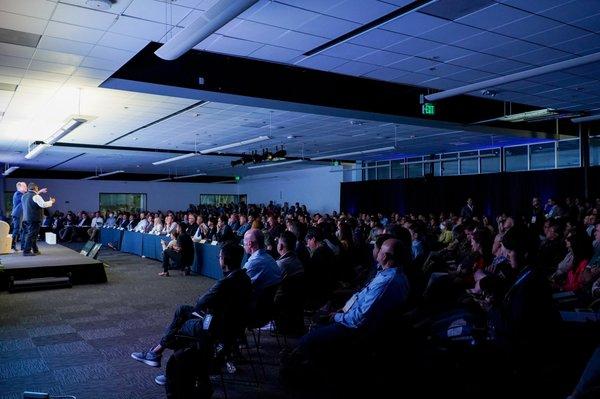 A room full of corporate executives, venture capitalists, startups, and tech enthusiasts listen to an engaging keynote speaker during Summit