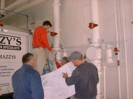 Mazzy's Fire Protection employees installing a sprinkler system.