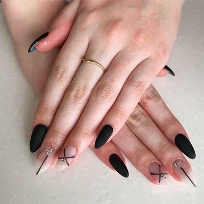 Black matte nails with abstract designs and gems