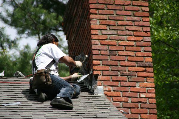 O'LYN Roofing contractor performing chimney flashing repairs