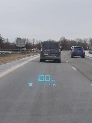 A van moving neither too fast nor too slow hanging out in the left lane.