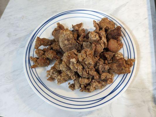 One order of Taiwanese chicken nuggets is still a generous portion that fills a large plate with a few pieces already being consumed.