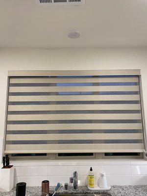 Blinds above kitchen sink in a cream color.