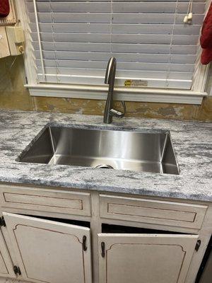 New kitchen single bowl sink with new granite countertops.