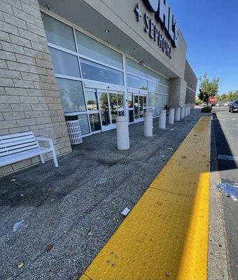 Trash littering the sidewalk in front of the store.