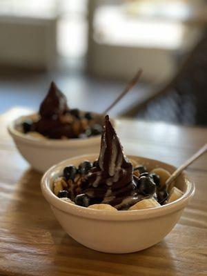 Small açaí bowl with blueberries, banana, granola, and condensed milk.