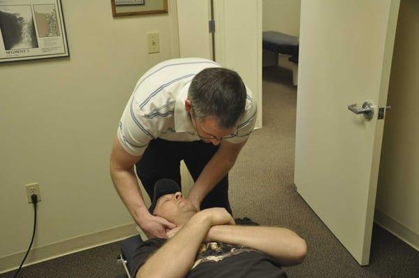 Dr. Graeme Gibson providing an a chiropractic adjustment to help with neck pain.