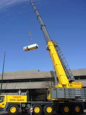 Our 275 Ton All Terrain Crane hoisting an air conditioning unit.