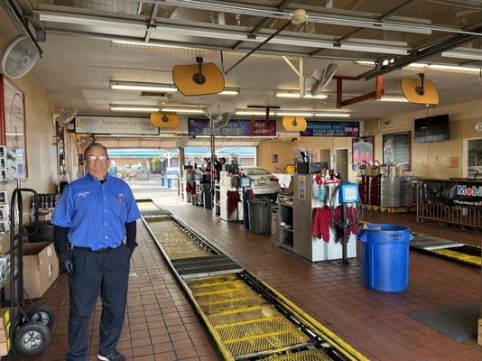 Happy Red Carpet Quick Lube employee posing in one of our two oil change lanes.