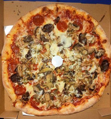 Whole pizza with beef sausage, pepperoni, and mushrooms.