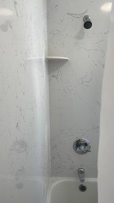 Service 4 Plumbing installed marble around the shower and tub that protects the walls and looks beautiful.