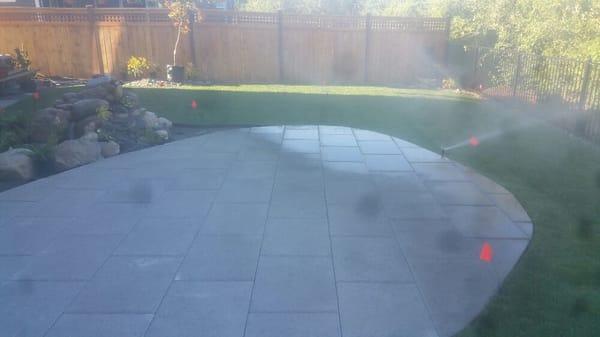 Lawn installation with sprinklers and patio.