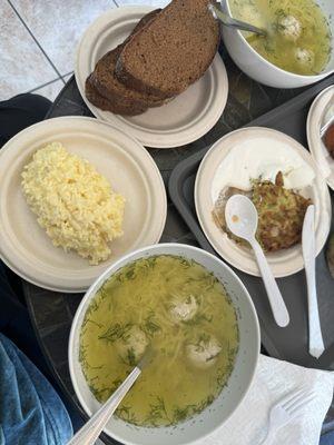 Chicken soup with rye bread and cheese spread. Zucchini pancake