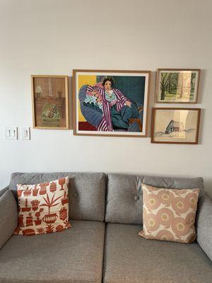 Gallery wall with custom framed piece in middle.