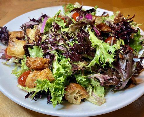 Pub house salad with blistered tomatoes and light vinaigrette dressing.