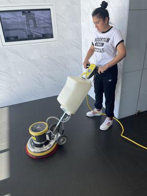 A cleaning lady using a rotary machine