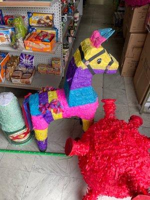 Three piñatas: a burro, a Dos Equis beer and a COVID virus molecule with spike protein.