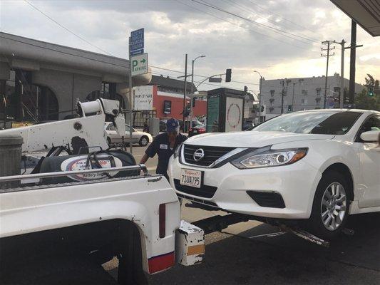 The AAA tow truck towing the dead car