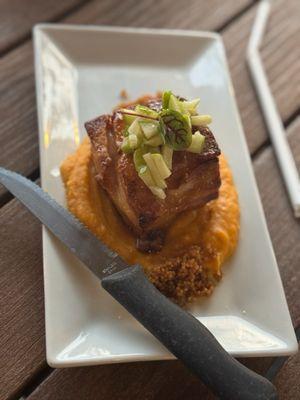 Special pork belly appetizer atop spiced sweet potato puree with apples and pickled mustard seeds