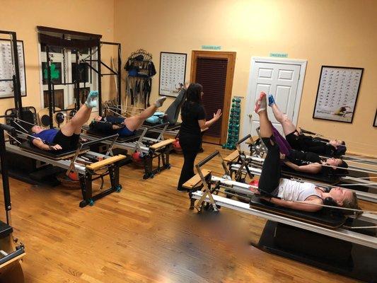 Kristen teaching a group Pilates Reformer class