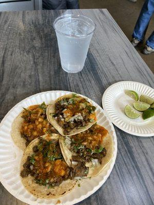 Carne asada tacos with onions cilantro red sauce and lime