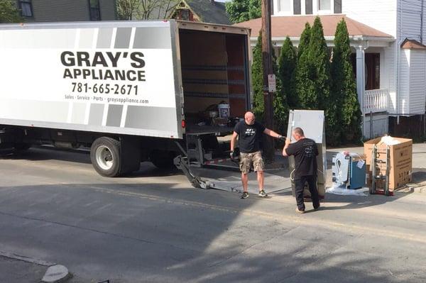 Jeremy and Rick unboxing and prepping appliances for delivery.