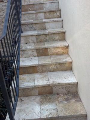 Travertine steps and a wrought iron hand railing