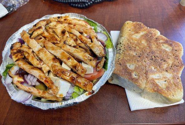 Grilled sweet chili chicken on greek salad with homemade bread.