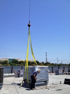 Crane dropping Carrier Package Unit on rooftop.