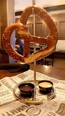 Giant pretzel starter with cheese and mustard sauce.