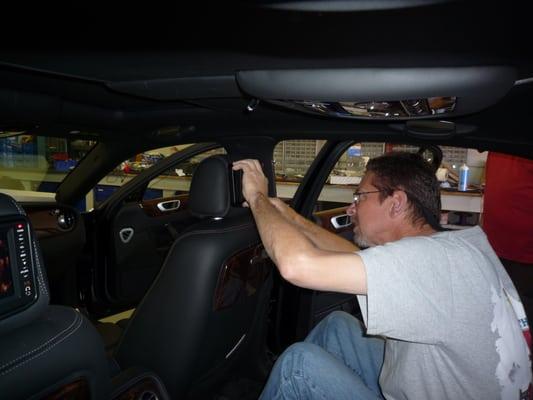 Technician installing video screen into Bentley headrest