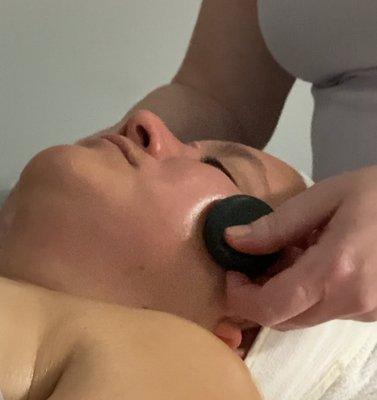 Facial massage with hot stones.