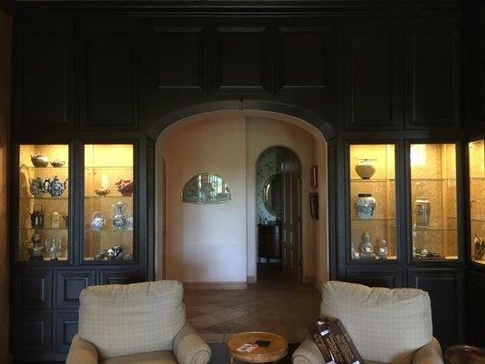 Floor to ceiling wall cabinetry with arch way to hall