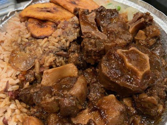 Oxtail over rice and peas will fried plantains and cabbage