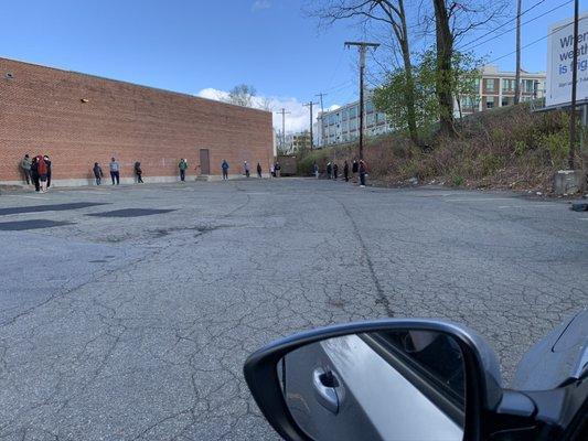 Line extending past the back of building on same day.