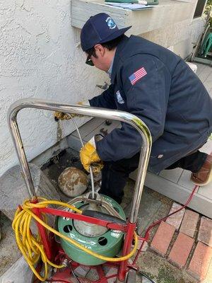 Jose, our field specialist, helping our drain tech run a cable through a kitchen clean out.