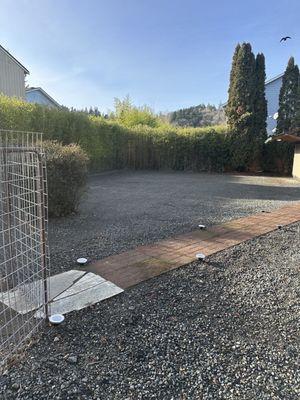 Backyard near bird station-left with Solar path lights. Pea gravel, crushed rock/gravel.