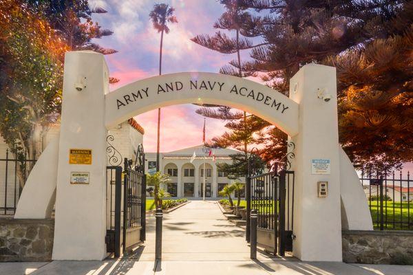 Front gates of Army and Navy Academy with Davis Hall in the background. During sunset.