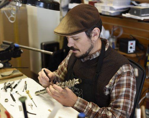 Rich repairs a flute at our on-site repair shop