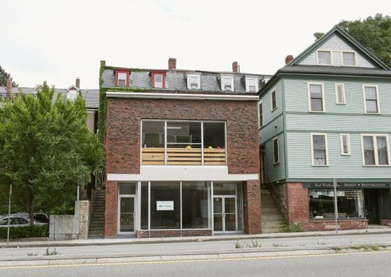 Look for the red door at the top of the stone steps to the left.