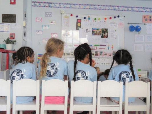 The kids listen attentively (in French!) to their teacher Ms. Audrey