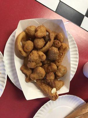 Sampler basket which includes mozzarella sticks, breaded mushrooms, breaded cauliflower, jalapeño poppers and onion rings