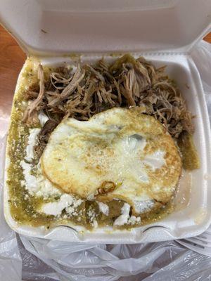 Chilaquiles verdes with 2 eggs over easy and carnitas.