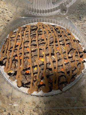 Reese's pie - brownie crust with a layer of peanut butter and vanilla ice cream, topped with peanut butter and fudge drizzle and Reese's