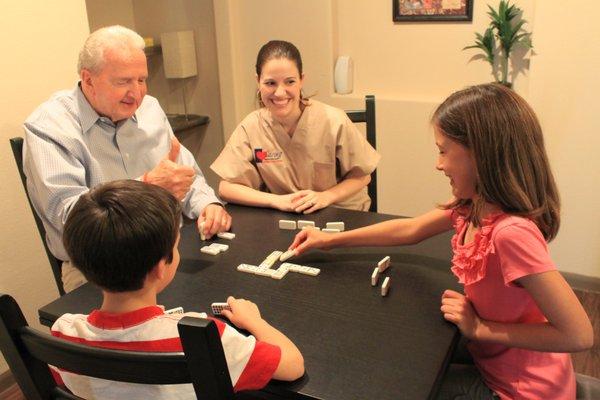 Caring Senior Service caregiver playing games with a client and his grandchildren