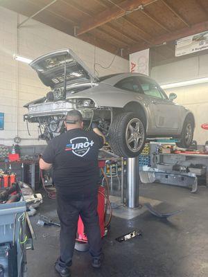 Heavy engine work on a beautiful Porsche.